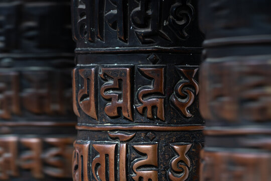 Close-up view on spinning prayer wheels with "&Oacute;m mani padme h&uacute;m" mantra of famous Swayambhunath stupa, known as monkey temple. Stupa is one of the most revered places in buddhism, Kathmandu, Nepal.