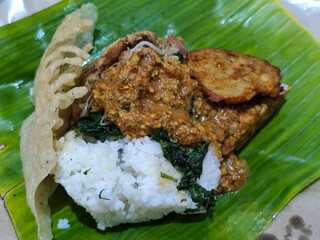 Nasi pecel and sego pecel are typical Javanese Indonesian rice dishes served with pecel sauce, vegetables and others.	