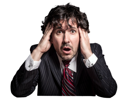 Man in suit, hands on head, looks shocked against black background