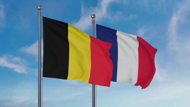 Two national flags of Belgium and France waving in the wind against a clear blue sky