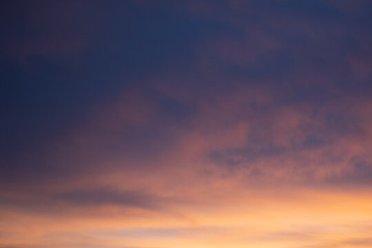 Sunset sky of blue and yellow colors. Summer nature background with clouds.