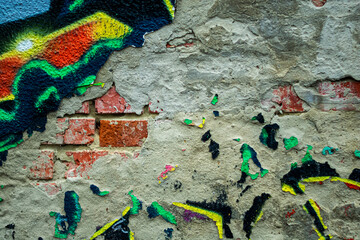 Abstract: crumbling graffiti on a city street wall. Colorful abstract background. Old, cracked, peeling paint serves as the backdrop.