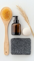A top-down view of spa products including a wooden brush, a bottle, a pumice stone, and a wheat stalk, arranged on a white background.