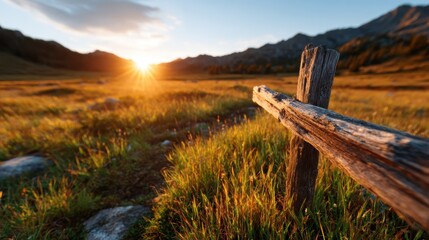 A serene sunset landscape features a rustic wooden cross positioned in a lush meadow, evoking feelings of peace and reflection amidst majestic mountain scenery.