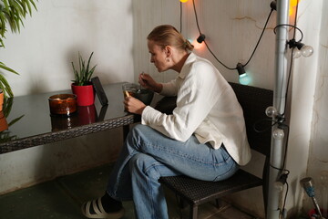 Woman eating soup while watching video on smartphone