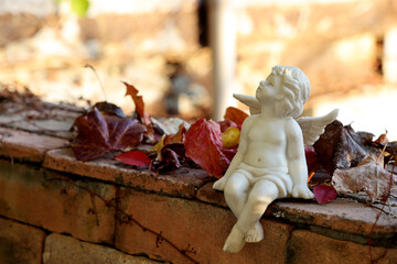 カラフルな紅葉とレンガに座る天使
