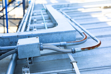 Good manage network electric cable with metal flex pipe. Isolated on white background. Installation of electrical wiring on wall. Electrical cable system installation.