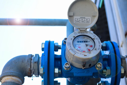 A water meter in the basement of a house, reading a water meter
