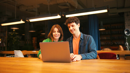 Colleagues, smiling woman and man having video conference meeting on laptop in modern office