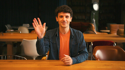 Professional man gesturing and talking during video call in a modern office