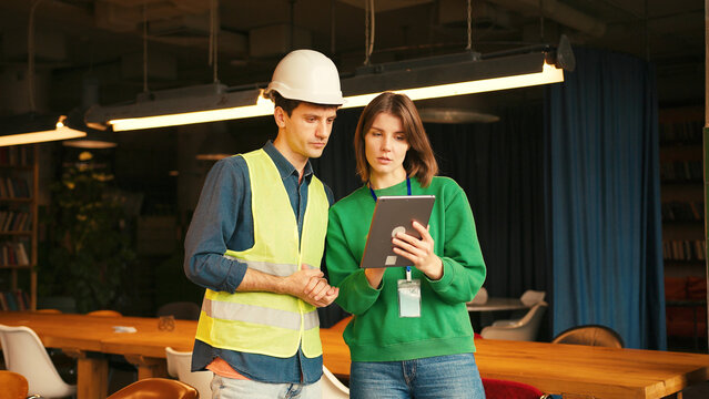 Architect and construction foreman discussing project on digital tablet