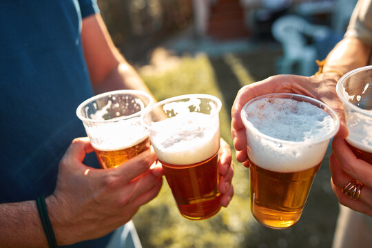 People holding beer cups and enjoying summertime outdoors.