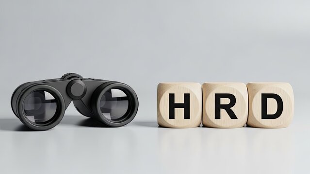 Binoculars and wooden blocks spelling hrd symbolizing human resources search and recruitment