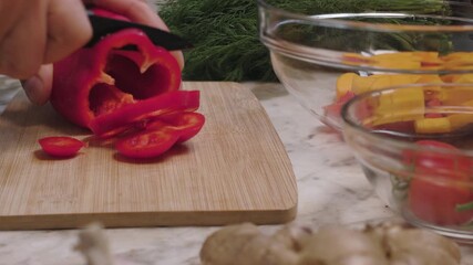 Slicing red pepper with a knife on a cutting board. Healthy eating. - Powered by Adobe