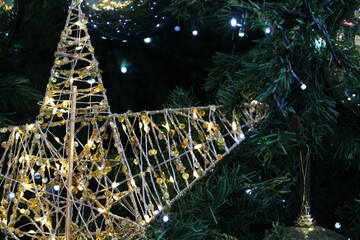 Close-up of a decorative star on a Christmas tree with twinkling lights