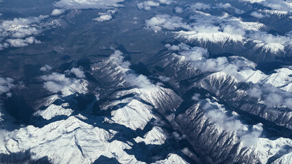Aerial View of Snow-Capped Mountain Peaks with Clouds, Scenic Landscape, Winter Wonderland