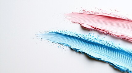 Close-up of pink and blue makeup swatches on a white background, showcasing textures and colors.