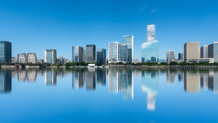 Fototapeta premium Modern city skyline with tall buildings reflecting in water