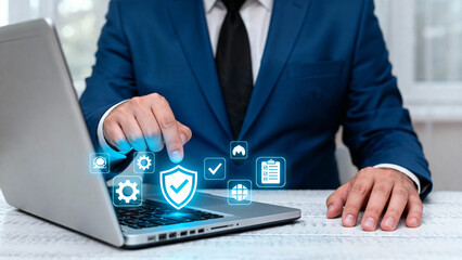 Business professional using laptop with digital security icons floating above keyboard
