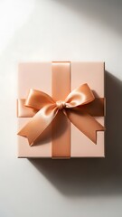 Top-down view of a pink gift box with a gold ribbon and bow.