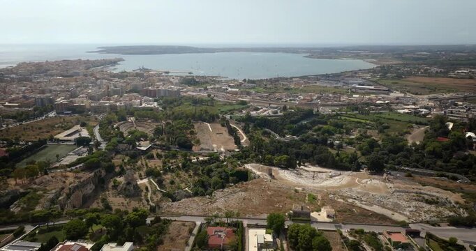Panoramic aerial view of the Neapolis Archaeological Park, located in Syracuse, Sicily, Italy. In the background there's the modern city overlooking the gulf of the same name and the island of Ortygia