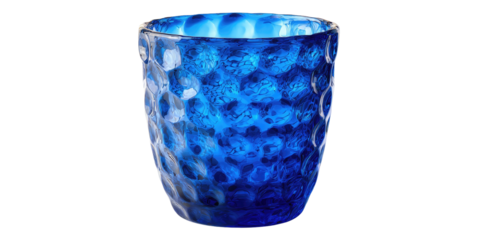 Close-up of a textured, blue glass. The drinkware has a honeycomb-like pattern, catching light