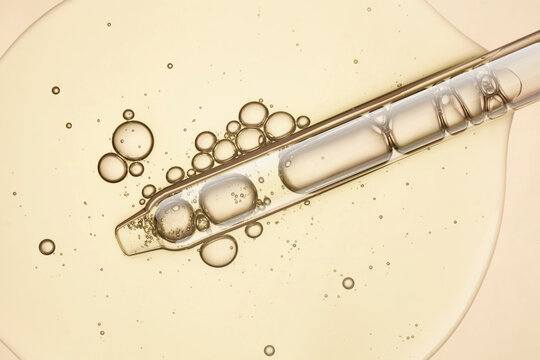 Liquid yellow gel or serum on white isolated background