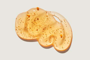 Orange yellow cleansing gel or serum with microcapsules mango colored mask sample on neutral beige background