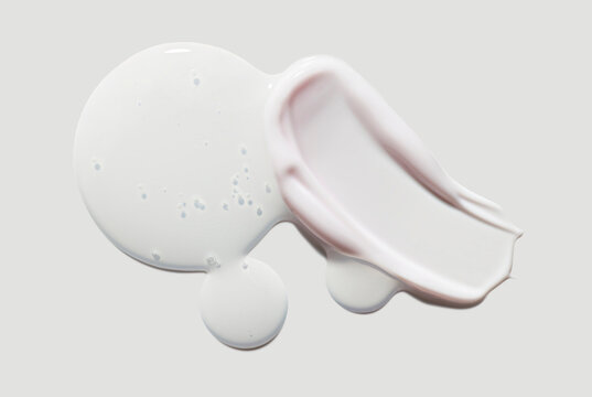 Cosmetic beauty product texture sample swatch. Two products mix set. Translucent gel serum or peeling and milky pink cream balm isolated on neutral grey