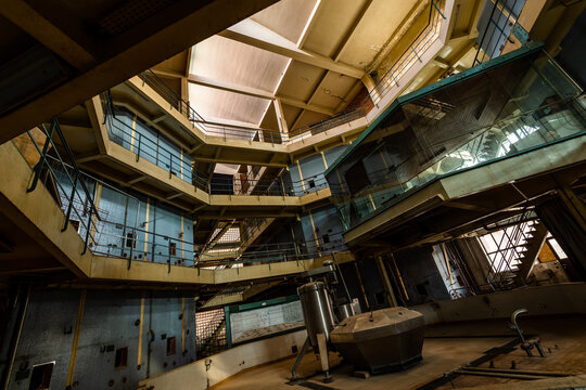 Abandoned octagonal winery interior with multi-level balconies, industrial tanks and skylight