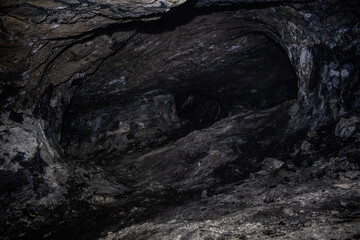 Dark Rock Chamber Interior with Textured Walls and Moody Lighting
