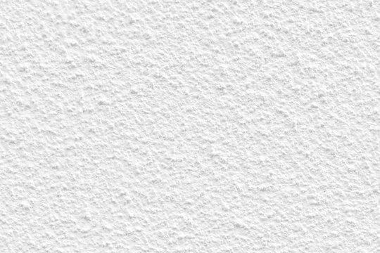 White concrete wall texture background. Uneven render stucco white painted concrete wall texture background. Rough and grunge wall in the sun.