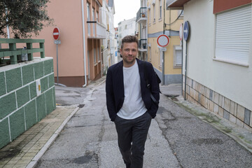 Middle aged man walking through narrow streets of Portugal