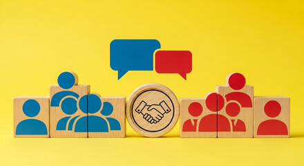 Wooden blocks depicting team collaboration negotiation and agreement with blue and red figures handshake icon and speech bubbles on a bright yellow background representing business partnership