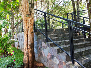 Modern park bridge and stone stairs with metal mesh railings