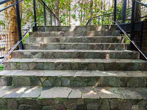 Modern park bridge and stone stairs with metal mesh railings - Powered by Adobe
