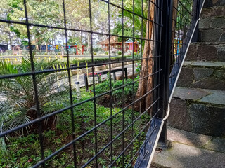 Modern park bridge and stone stairs with metal mesh railings