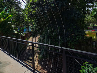 Modern park bridge and stone stairs with metal mesh railings