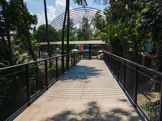 Modern park bridge and stone stairs with metal mesh railings