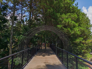 Modern park bridge and stone stairs with metal mesh railings
