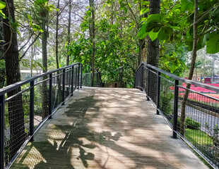 Modern park bridge and stone stairs with metal mesh railings