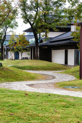 A peaceful path leading to modern houses in a green environment