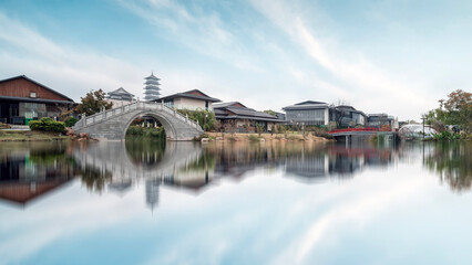 Traditional Chinese architecture with a stone bridge and calm water