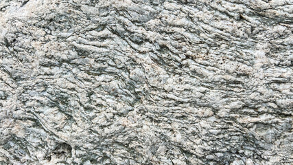 Close-up texture of rough gray rock surface with natural patterns