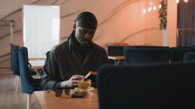 focused individual editing at cafe, creative professional revising document in welcoming coffee setting, dedicated editor immersed in work at cafe with peaceful and inviting environment