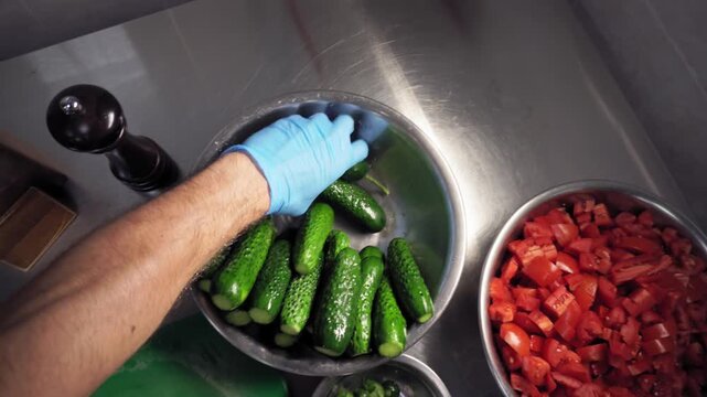 A chef with kitchen knife cuts the cucumbers unusable parts with quick movements