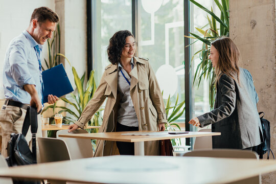 Three Team Members Celebrating Successful Conference Presentation at Venue Cafe