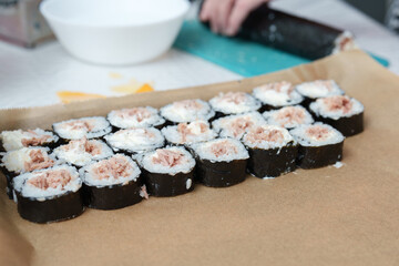 Homemade sushi rolls arranged neatly on brown paper, waiting to be enjoyed at lunchtime