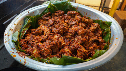 A large container of spicy seasoned chicken ready to be grilled into spicy grilled chicken at one...