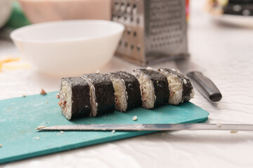 Slices of homemade nori rolls on a blue cutting board show off culinary skills in the kitchen